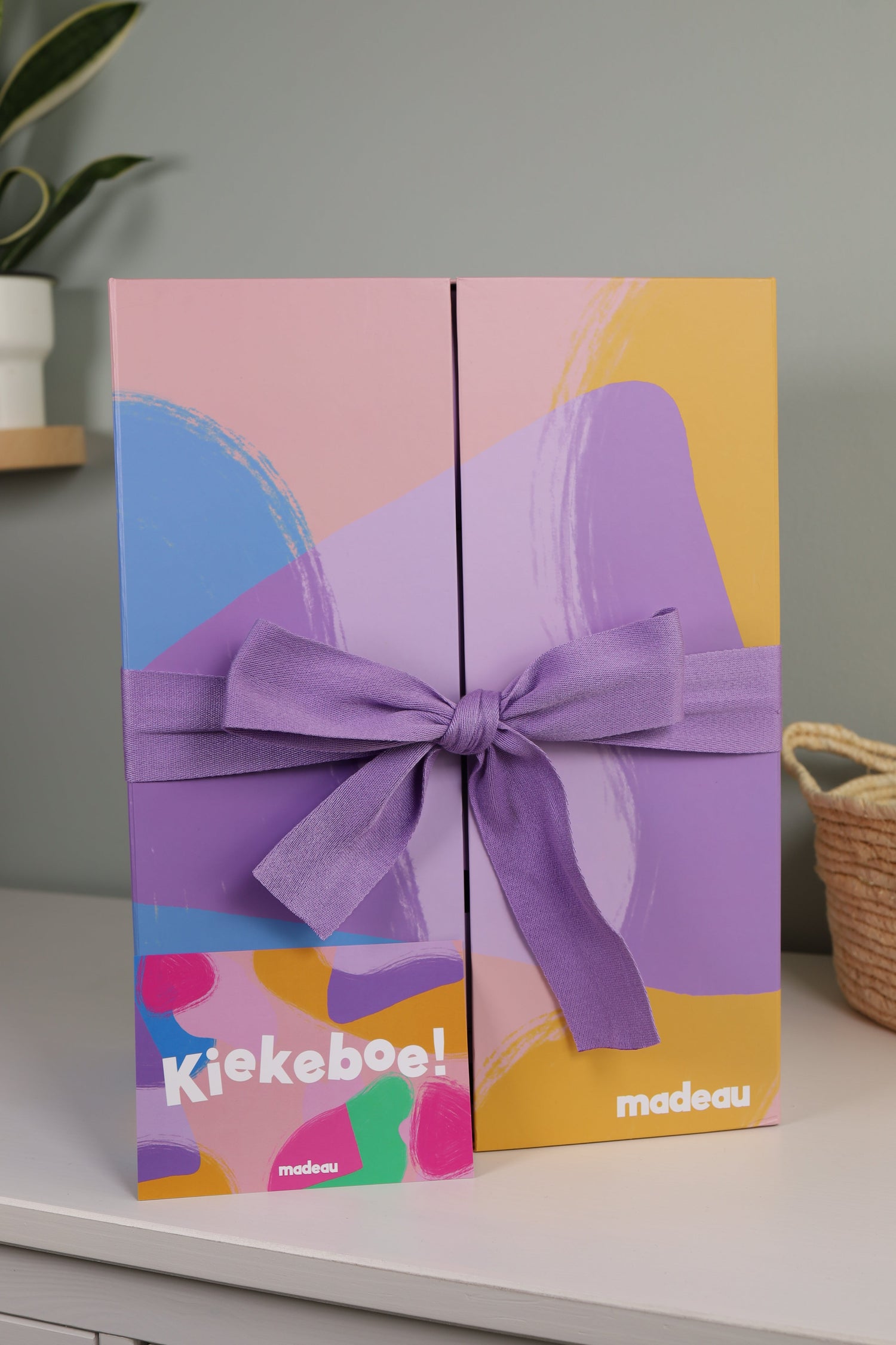 Madeau-box met gesloten strik en kaartje op een commode